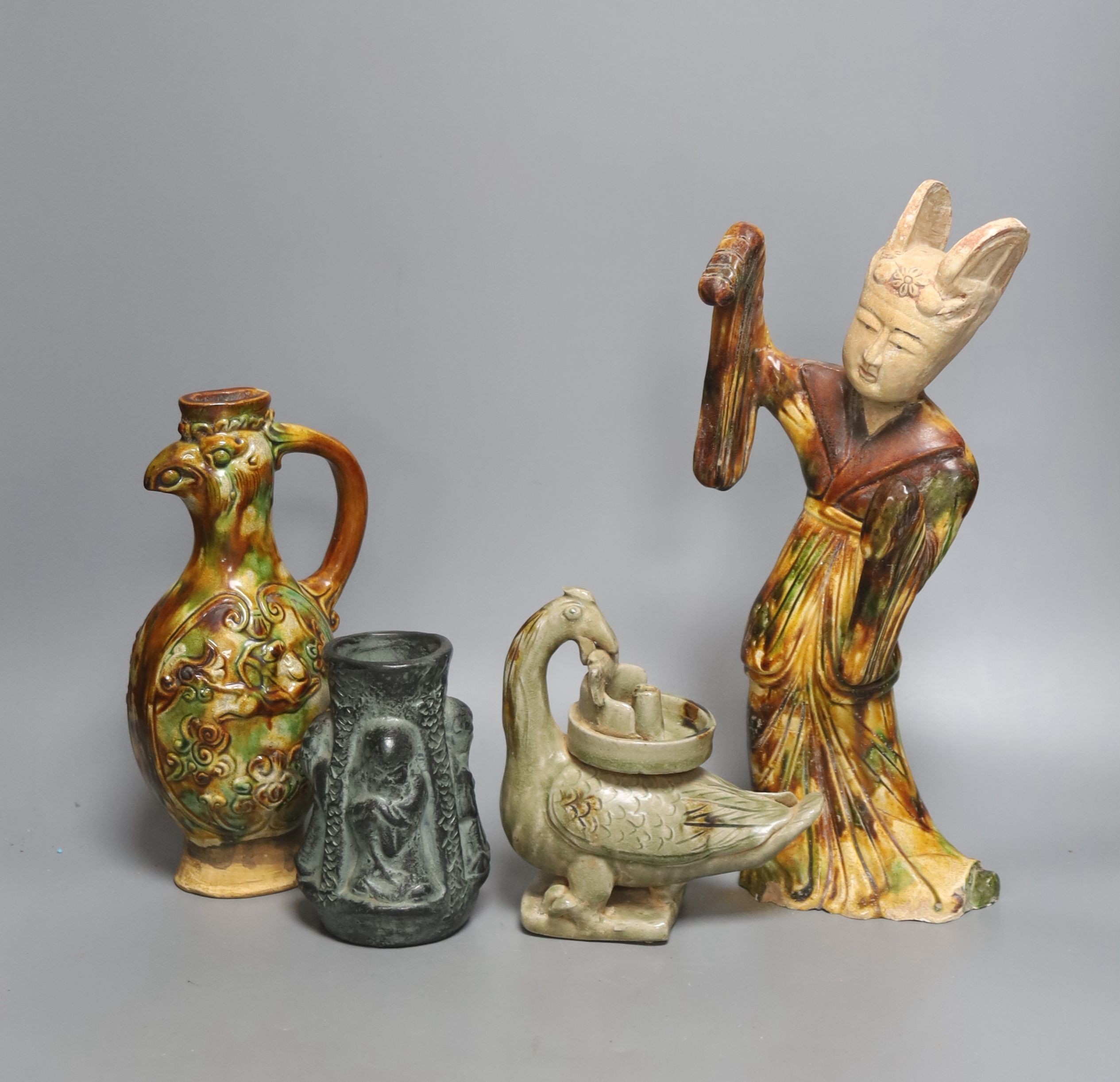 A Chinese Tang style sancai figure of a lady, a similar phoenix head ewer, a Yue type oil lamp and another vessel (4)